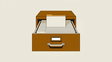 A card-index drawer with blank filing cards, one lifted above the rest